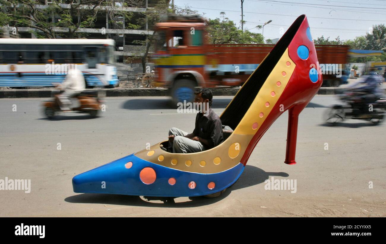 A worker test drives a car in the shape of a heels on a road in the  southern Indian city of Hyderabad March 7, 2012. The shoe is part of a  ladies
