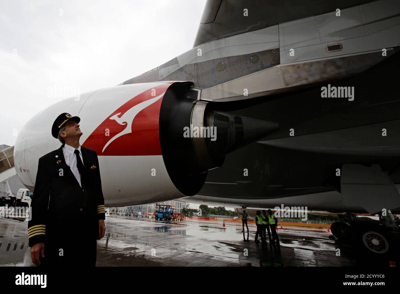 Qantas Airways pilot Captain Richard Champion de Crespigny stands in front  of the replaced number 2 Rolls Royce Trent 900 engine of the repaired  Qantas A380 VH-0QA passenger jet on the tarmac