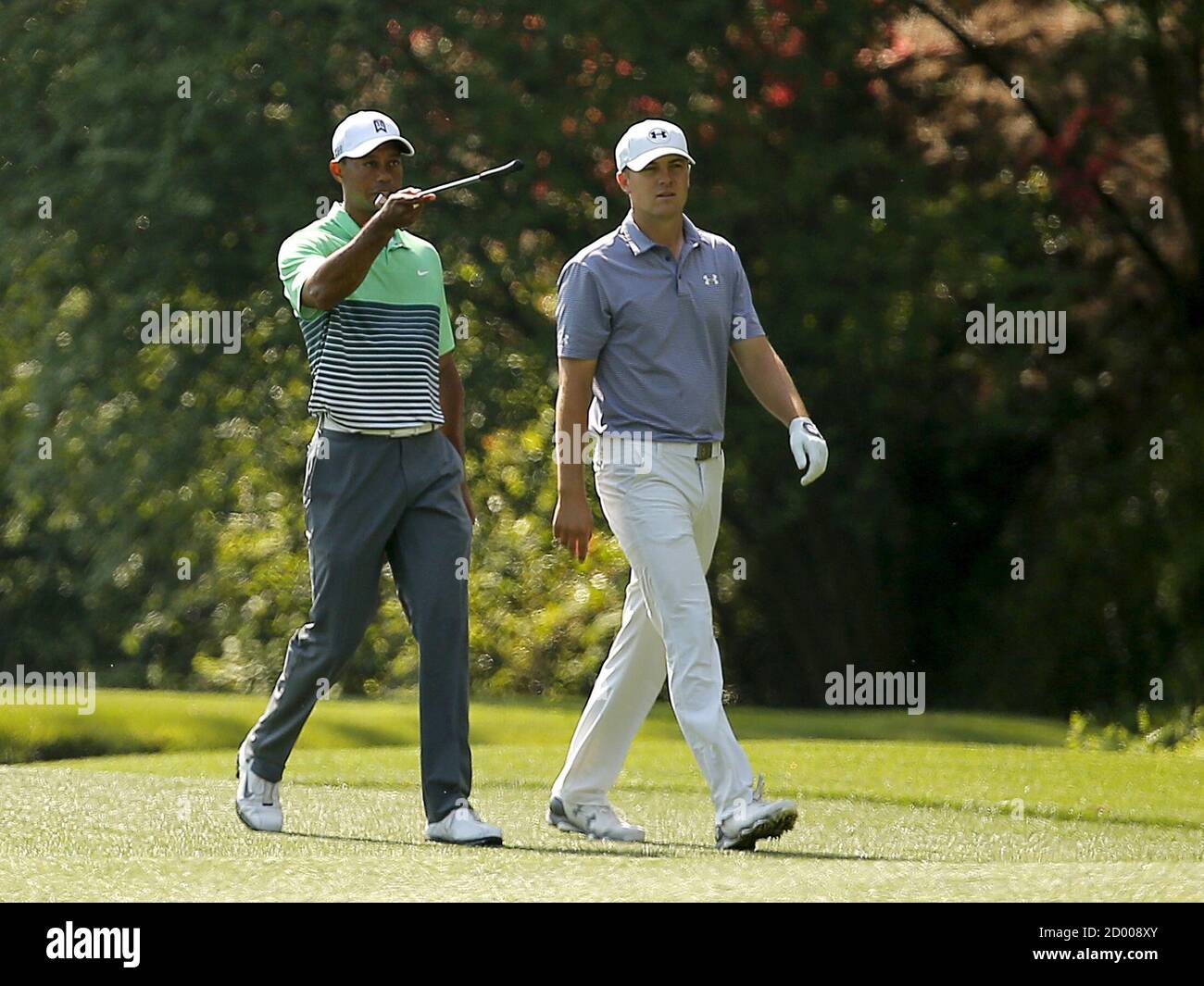 Jordan Spieth (R) gets some pointers from Tiger Woods as they walk up the 13th fairway during a round ahead of the 2015 Masters at Augusta National Golf Course in Augusta, Georgia April 8, 2015. Spieth's sublime putting on some of the most treacherous greens in golf, which set up his Masters victory on Sunday, was underpinned by his imaginative touch, says putting maestro Ben Crenshaw. Picture taken April 8, 2015. REUTERS/Brian Snyder Stock Photo