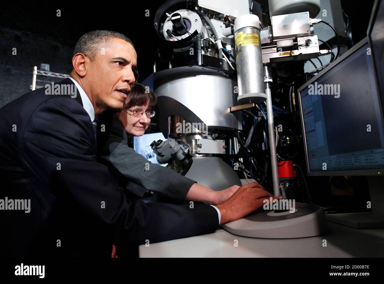 U.S. President Barack Obama (L) looks at a screen next to Intel's Transmission Electron Microscope during a tour of the semiconductor manufacturing facility at Intel Corporation in Hillsboro, Oregon February 18, 2011.  Pictured with Obama is telescope lab manager Barbara Miner.   REUTERS/Kevin Lamarque (UNITED STATES - Tags: POLITICS BUSINESS) Stock Photo