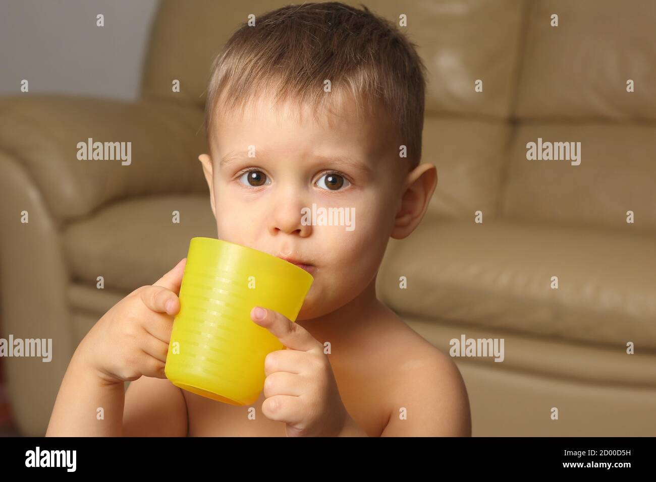 little boy drinking from a plastic Cup Stock Photo