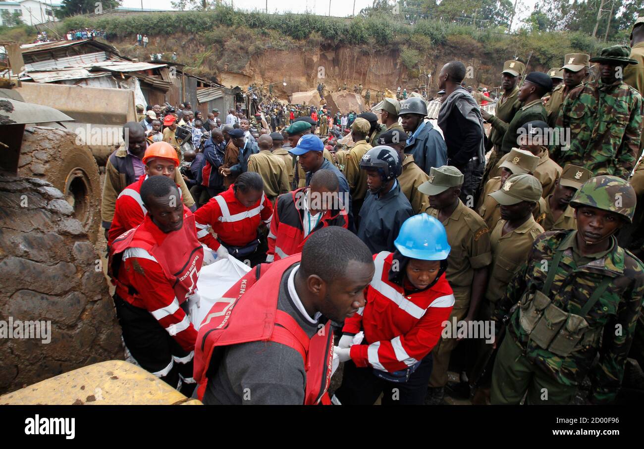 Members of the Kenyan Red Cross (L) carry the remains of a man killed during a landslide at the Mathare valley slum after boulders, rocks and mud tumbled down a hillside overlooking the slum, smashing into the houses and burying the occupants in Kenya's capital Nairobi, April 4, 2012. More than four people are feared dead while scores of others are trapped as the heavy rains led to a landslide in one of Kenya's biggest slums crammed with tin and mud shanty houses. Rescue officials said the cramped nature of the slum dwellings were hindering the rescue operations. REUTERS/Thomas Mukoya (KENYA - Stock Photo