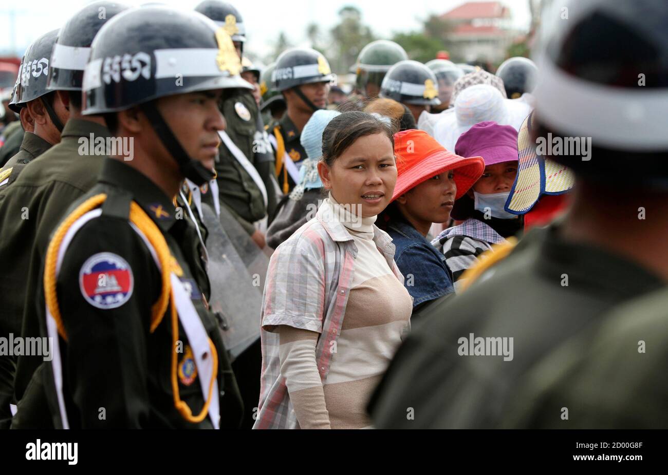 Police block the street as workers march from a garment factory in Kandal province to protest at the Ministry of Labor & Vocational Training in capital Phnom Penh July 5, 2012 .Thousands of workers at the factory, which supplies clothes to U.S. brands Levi Strauss and Old Navy, blocked traffic on a road during their ongoing strike which began in May to demand better pay and more benefits, protesters and police told local media. REUTERS/Samrang Pring (CAMBODIA - Tags: BUSINESS EMPLOYMENT CIVIL UNREST) Stock Photo