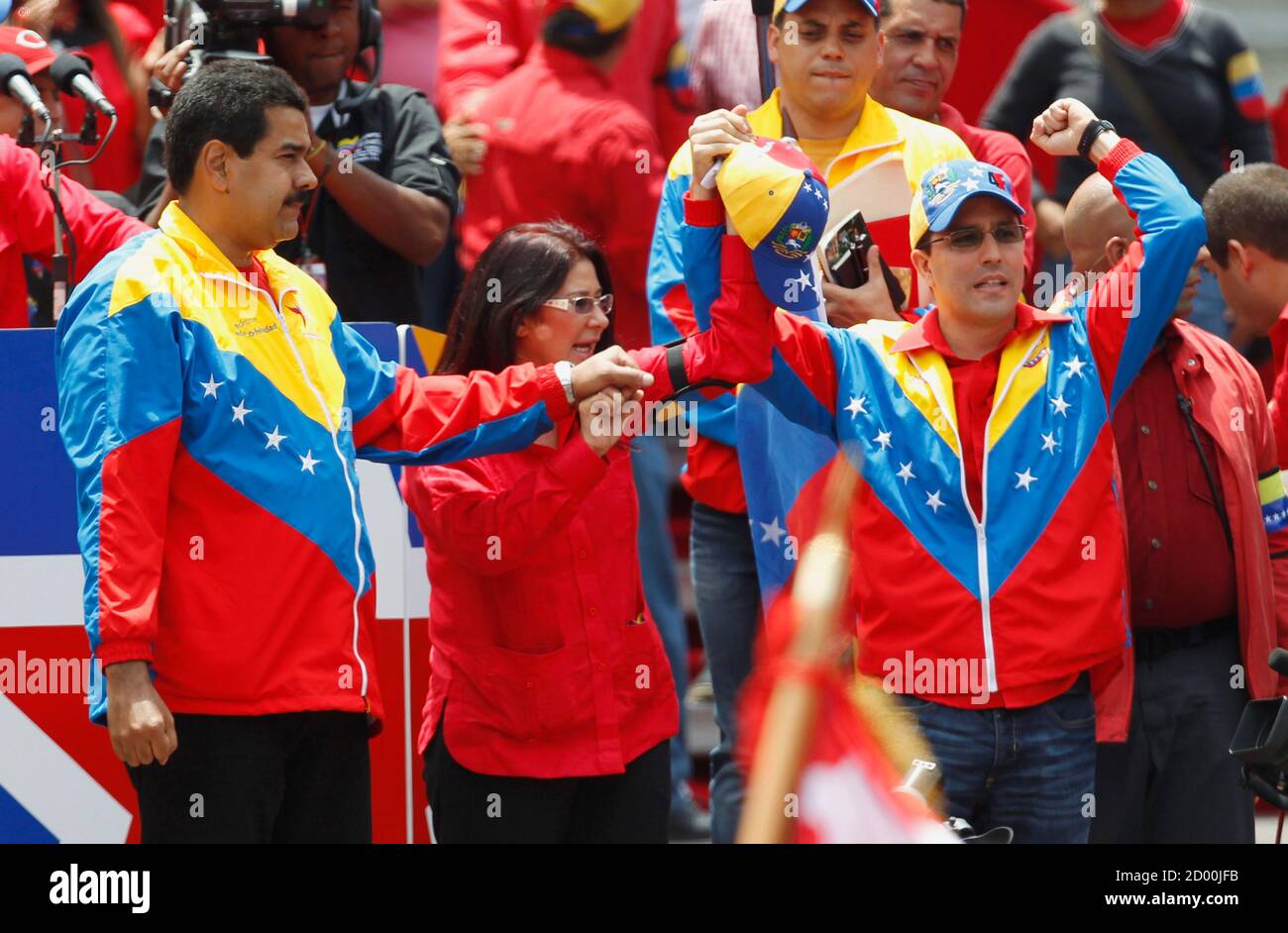 L-R) Venezuela's acting President Nicolas Maduro, his wife Cilia Flores and  vice-presidential candidate Jorge Arreaza, who is the son-in-law of the  late President Hugo Chavez, greet supporters after Maduro registered as a