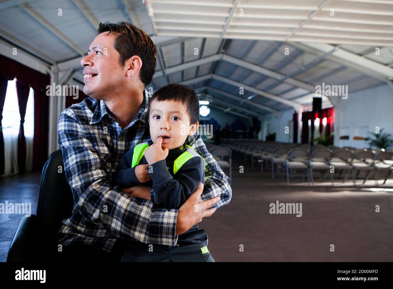 David Amaya holds 3-year-old Isaac Moreno, a young boy in daycare at Iglesia  de Cristo Ministerios Llamada Final in San Diego, California November 24,  2013. Amaya was abducted as a child to