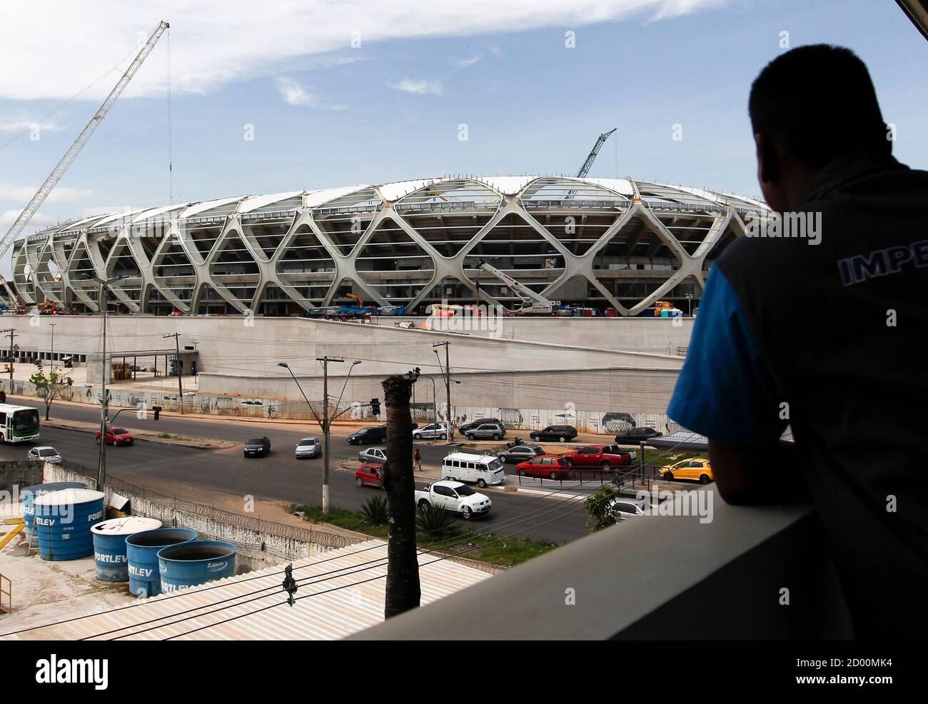 A worker observes the Arena Amazonia stadium under construction to host several 2014 World Cup soccer games, in Manaus December 14, 2013. Construction worker Marcleudo de Melo Ferreira fell to his death from the roof earlier in the day after a cable broke, adding to safety concerns as the country races to finish building in time to host the 2014 World Cup of soccer. REUTERS/Bruno Kelly (BRAZIL - Tags: SPORT SOCCER WORLD CUP DISASTER BUSINESS CONSTRUCTION) Stock Photo