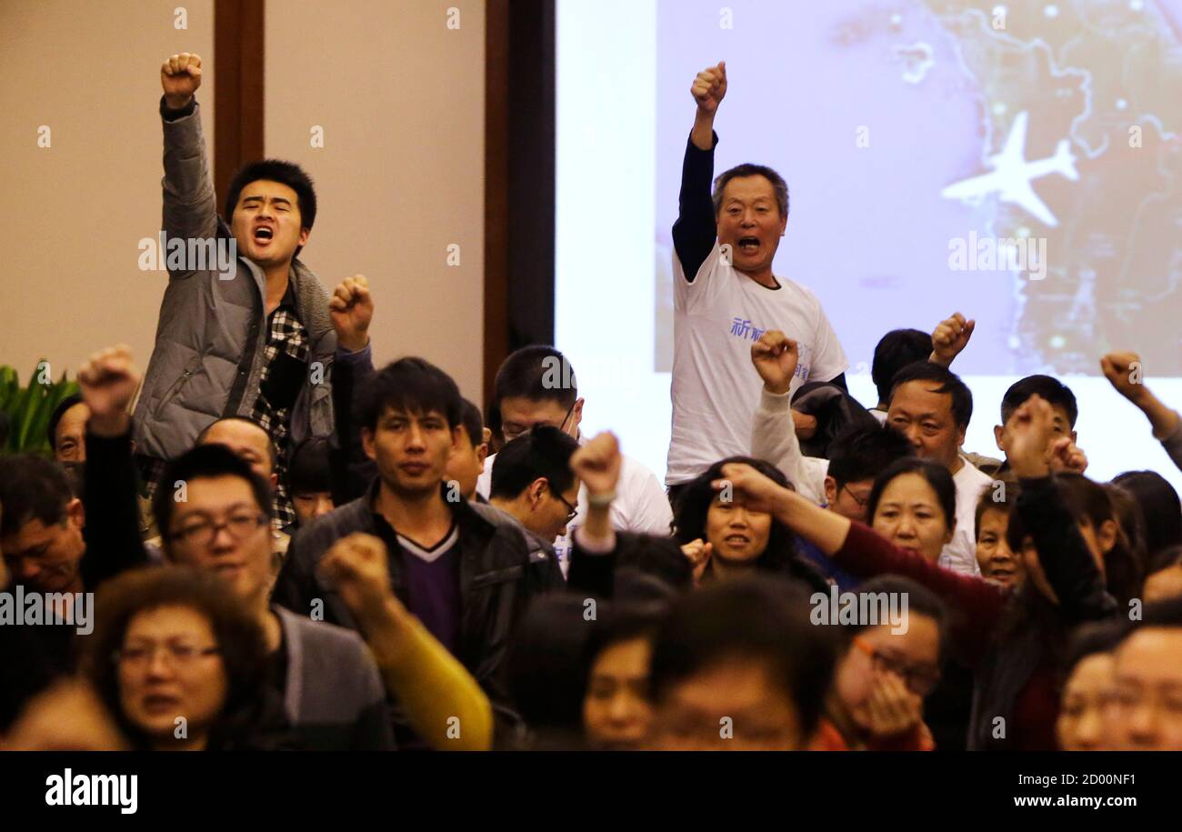 Family members of passengers onboard Malaysia Airlines Flight MH370 raise their fists as they shout 'return our families' to protest against the lack of new information after a routine briefing given by Malaysia's government and military representatives at Lido Hotel in Beijing March 22, 2014. Two weeks after a Malaysia Airlines airliner went missing with 239 people on board, officials are bracing for the 'long haul' as searches by more than two dozen countries turn up little but frustration and fresh questions. REUTERS/Jason Lee (CHINA - Tags: DISASTER TRANSPORT) Stock Photo