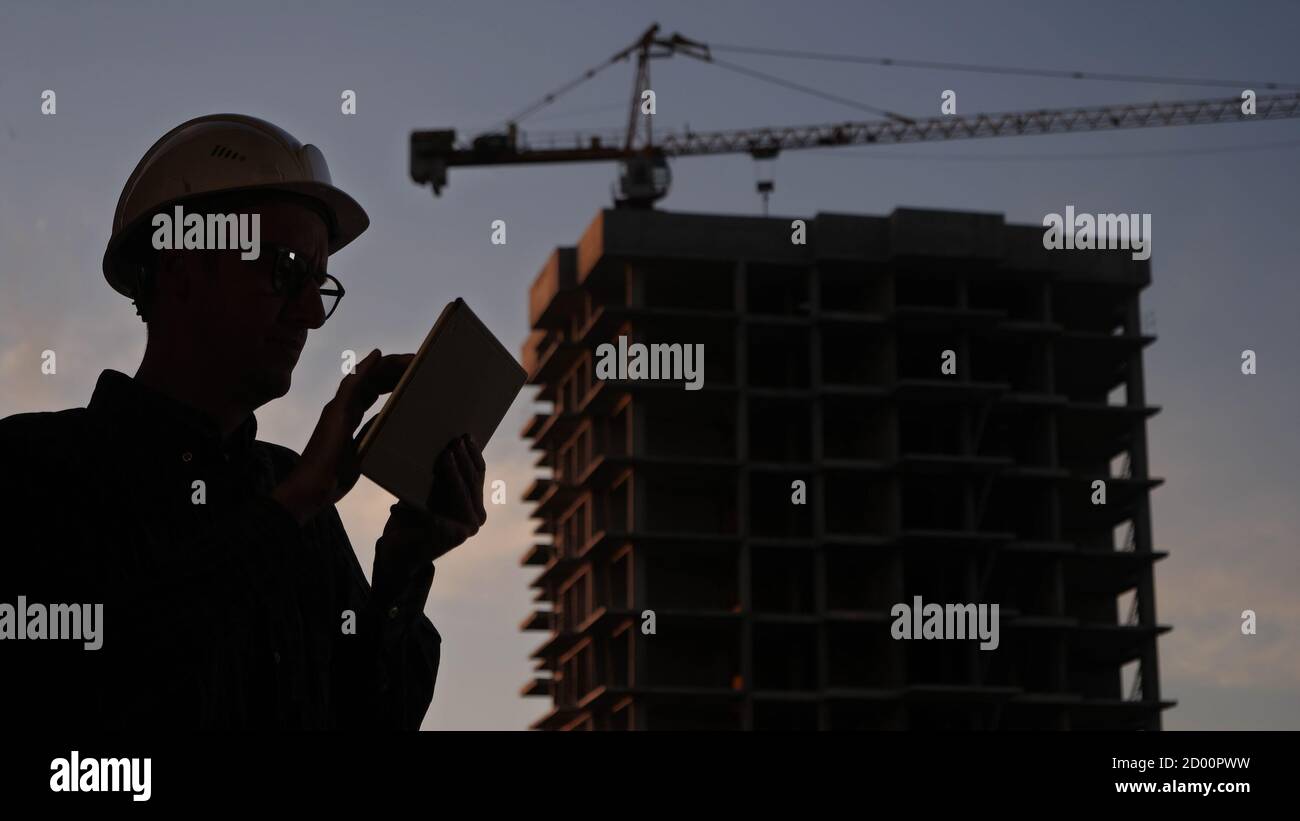 Construction manager using tablet on building site. Stock Photo