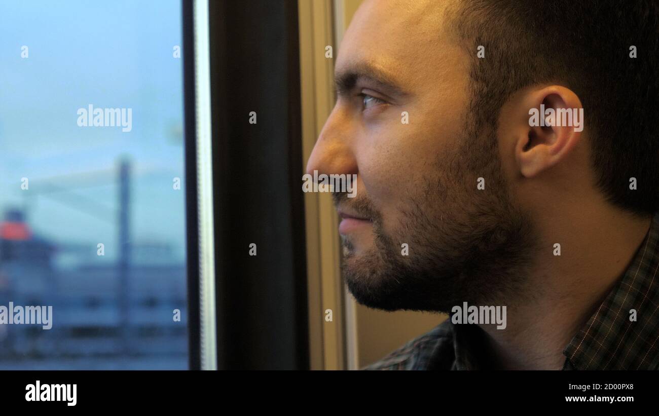 Young man thinking and looking at window in train Stock Photo - Alamy
