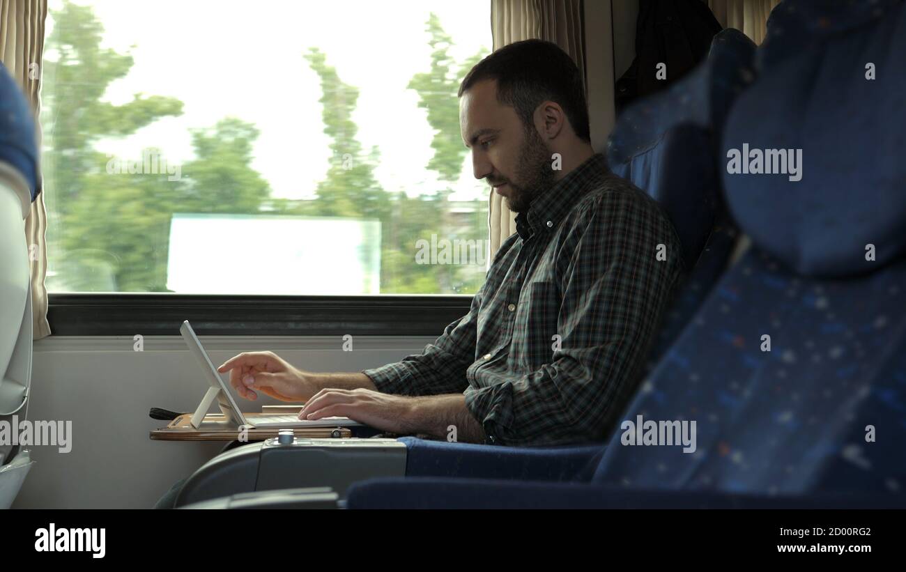 Handsome man using digital tablet while travelling in train. Stock Photo