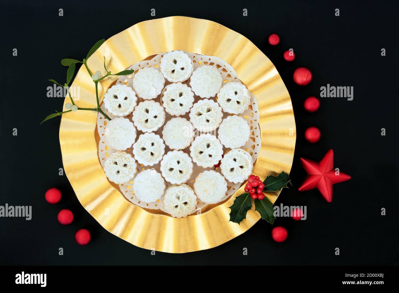 Traditional Christmas mince pie tarts on a gold plate with winter berry ...