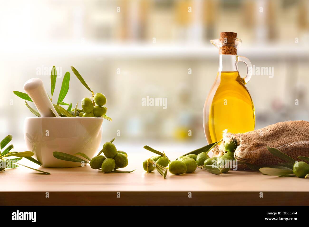 Preparation of olive oil seed in ceramic glass for body and culinary care  on table with mortar and sack of olives. Front view Stock Photo - Alamy