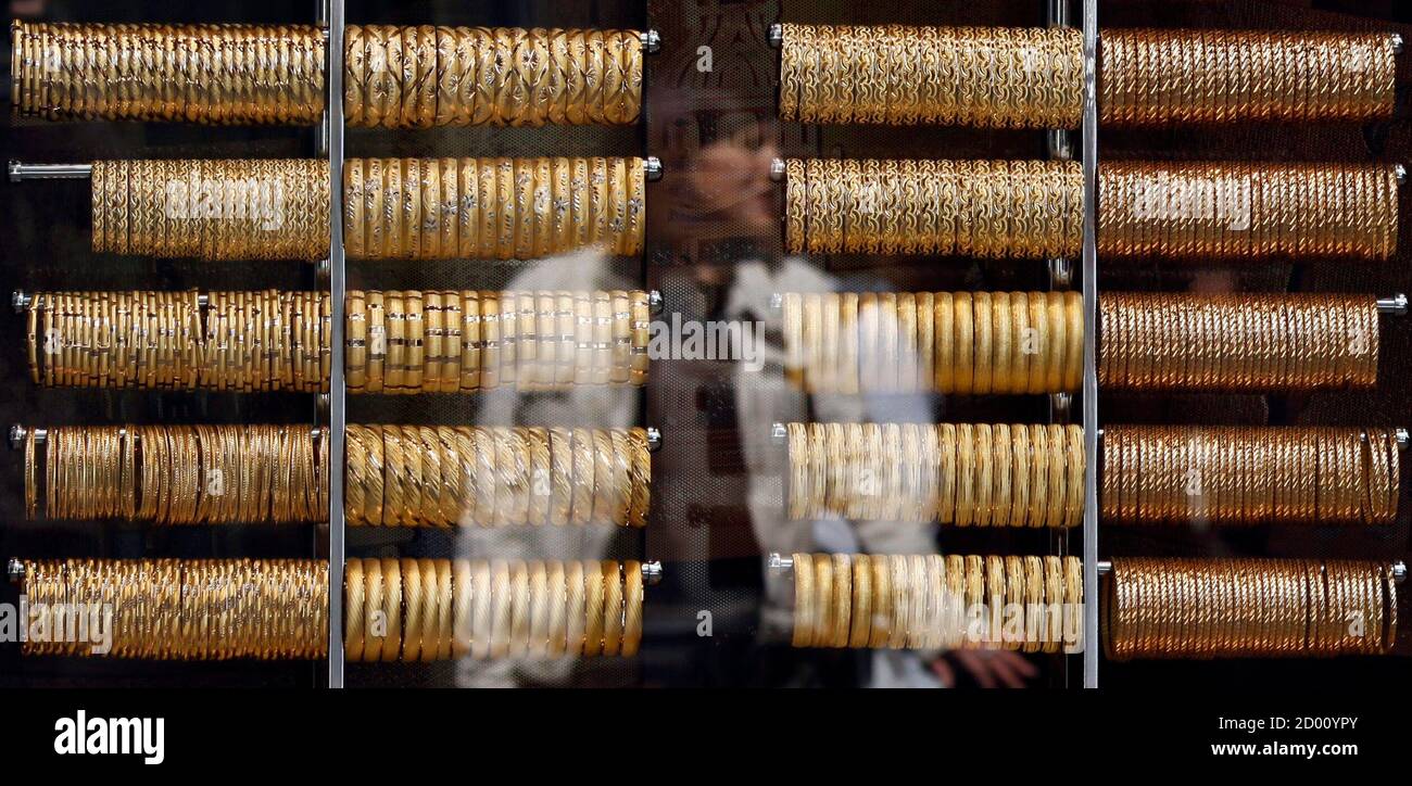 A woman is reflected on the window of a jewellery shop where gold bangles are on display in Istanbul April 22, 2011. Spot gold surged to a lifetime high on Friday in thin holiday trade, hitting a record for a sixth consecutive session on a weak dollar and factors ranging from geopolitical uncertainty to inflation concerns. REUTERS/Murad Sezer (TURKEY - Tags: BUSINESS) Stock Photo