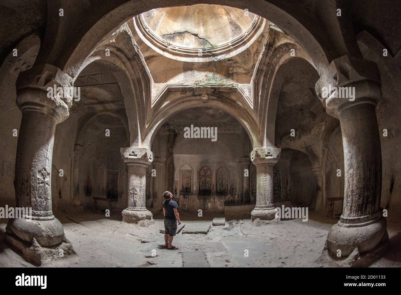 A tourist looking at the roof of the gavit of the Geghard monastery in Armenia. Stock Photo