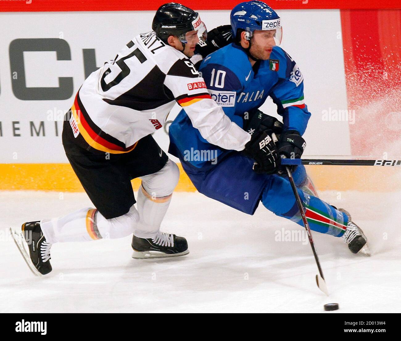 Italy's Giulio Scandella (R) fights for puck with the Germany's Felix Schutz  during their 2012 IIHF ice hockey Worlds Championship Group S game in  Stockholm May 4, 2012. REUTERS/Petr Josek (SWEDEN -