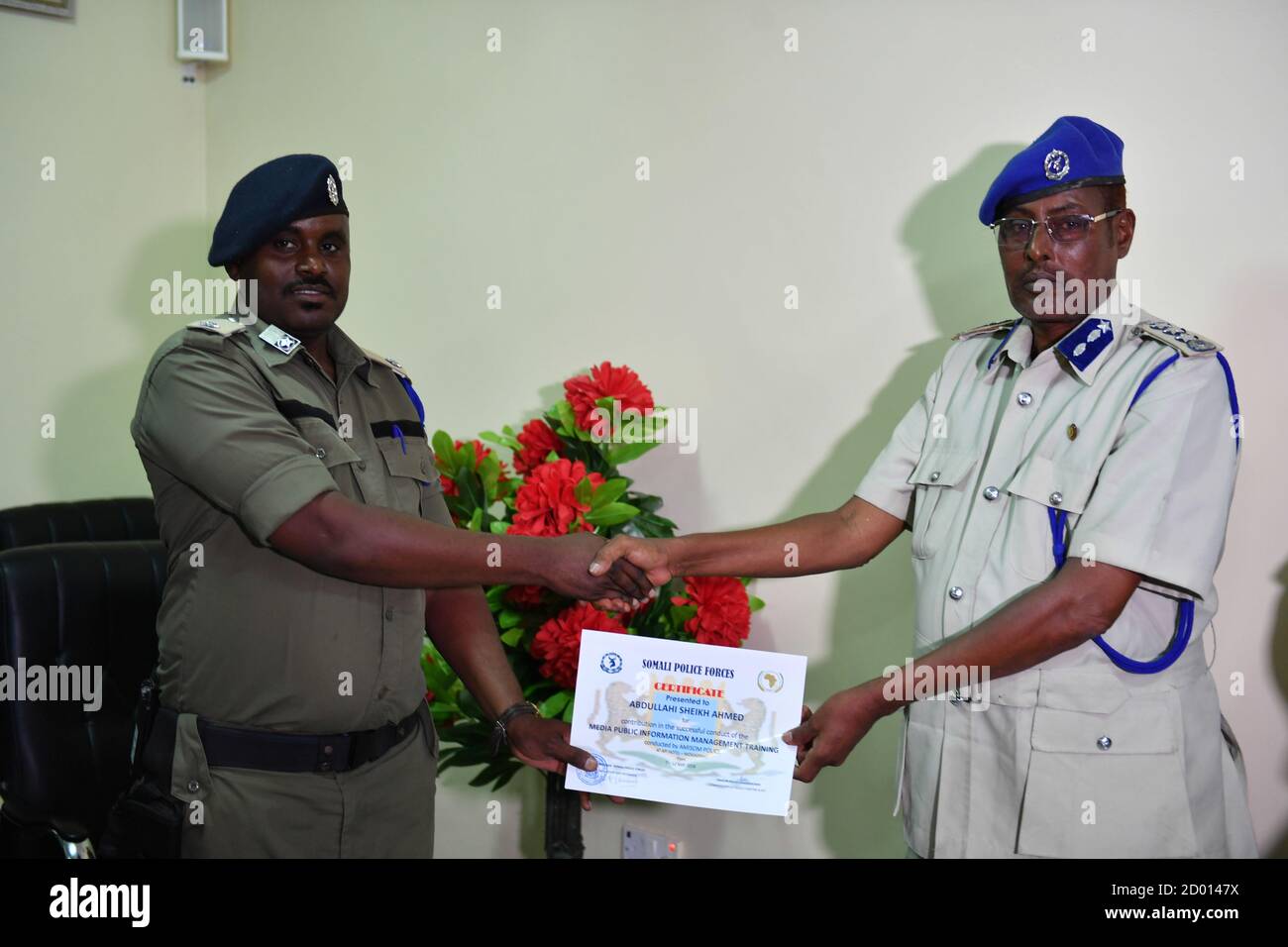 Gen. Hassan Alasow Mohamed, Director of Training and Planning for the Somali Police Force (SPF) hands over a certificate to a police officer at the closing ceremony of one-week training workshop on Media and Public Relations in Mogadishu, Somalia on May 12, 2018.  The training was organized and supported by the African Union Mission in Somalia (AMISOM). Stock Photo