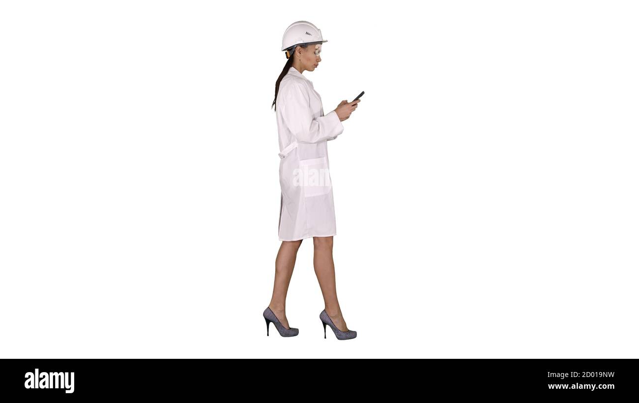 Engineer using mobile phone texting while walking on white backg Stock Photo