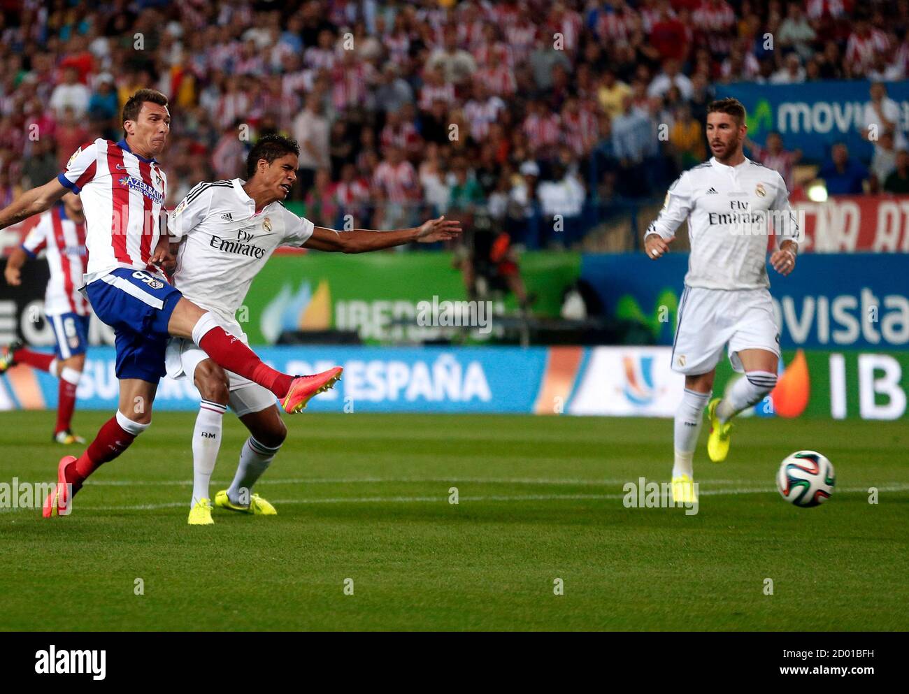 Atletico Madrid S Mario Mandzukic Kicks To Score Past Real Madrid S Raphael Varane And Sergio Ramos L R During Their Spanish Super Cup Second Leg Soccer Match At Vicente Calderon Stadium In Madrid August