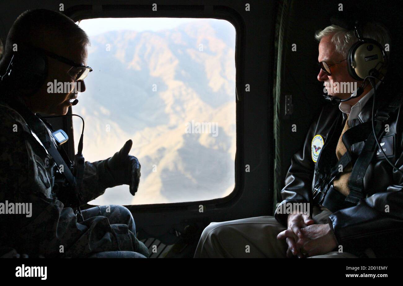 U.S. Secretary of Defense Robert Gates (R) receives a briefing from Major Gen. John Campbell while flying aboard a helicopter over Kunar Province on his way to meet U.S. soldiers in Afghanistan, December 7, 2010. Gates arrived today in Afghanistan for an unannounced visit during a tour of the region this week. The White House is conducting a review of the war in Afghanistan a year after President Barack Obama unveiled a revised strategy to battle Taliban militants and ease violence in one of the world's poorest nations.  REUTERS/Win McNamee/Pool  (AFGHANISTAN - Tags: MILITARY POLITICS) Stock Photo