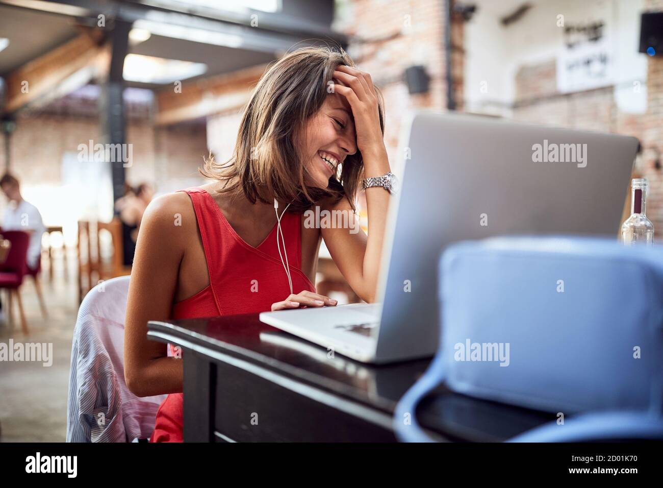 A young beautiful girl at a cafe delighted by video chat with a friend Stock Photo