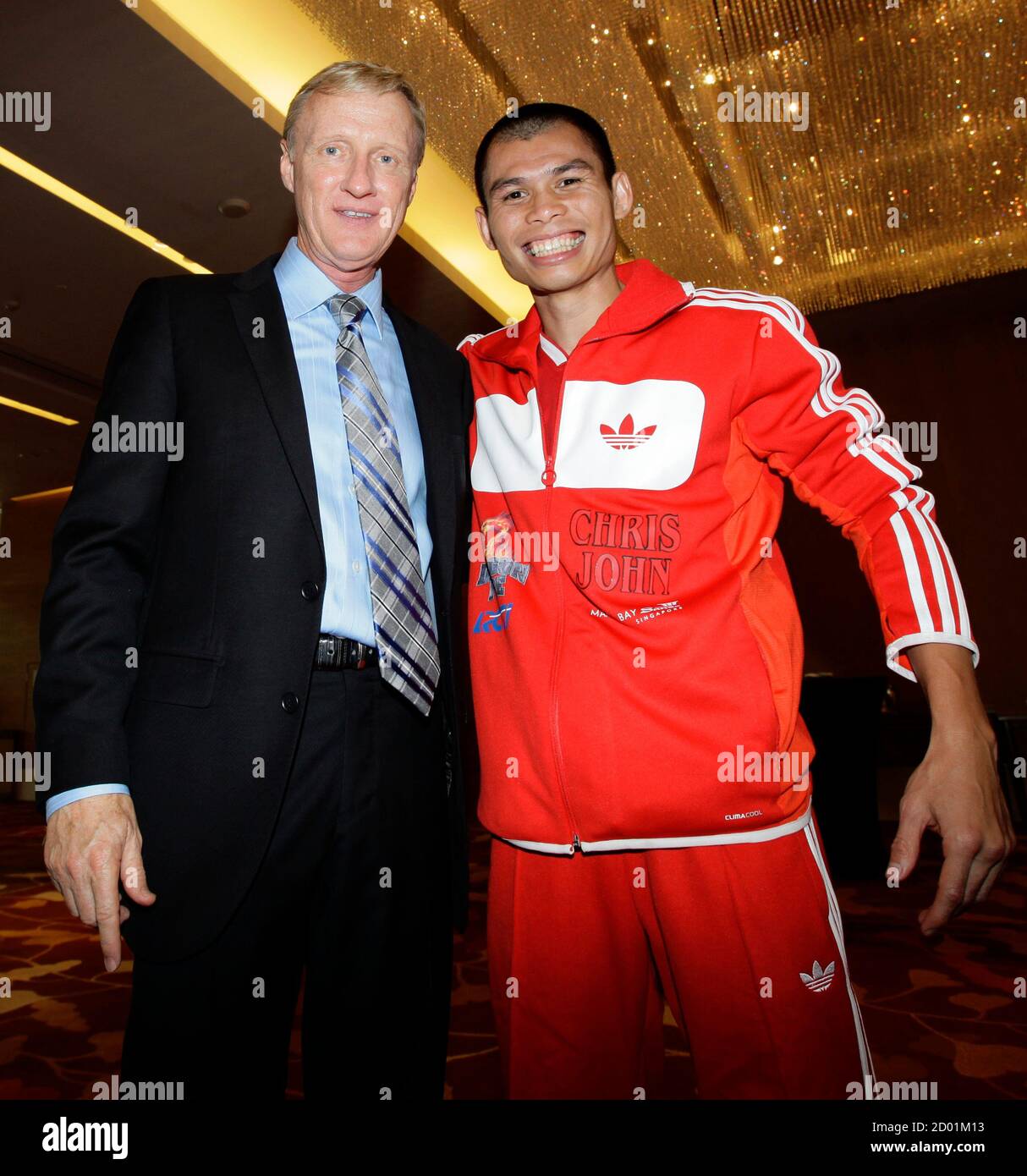 Boxer Chris John (R) of Indonesia, the undefeated World Boxing Association  (WBA) super featherweight world champion, poses for souvenir photos with  U.S. boxing ring announcer Jimmy Lennon Jr. after a news conference
