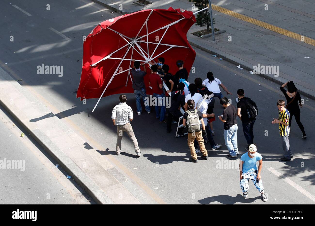 Protesters use a huge umbrella as a shield as they clash with riot police in Ankara June 3, 2013. Turkish Prime Minister Tayyip Erdogan accused anti-government protesters on Monday of walking 'arm-in-arm with terrorism', remarks that could further inflame public anger after three days of some of the most violent riots in decades. Hundreds of police and protesters have been injured since Friday in the riots, which began with a demonstration to halt construction in a park in an Istanbul square and grew into mass protests against what opponents call Erdogan's authoritarianism. REUTERS/Umit Bektas Stock Photo