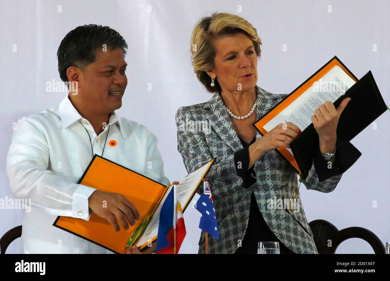 Australian Foreign Minister Julie Bishop (R) Education Secretary Armin Luistro documents after signing them during her visit to a school in Mandaluyong city, metro Manila February 21, 2014.