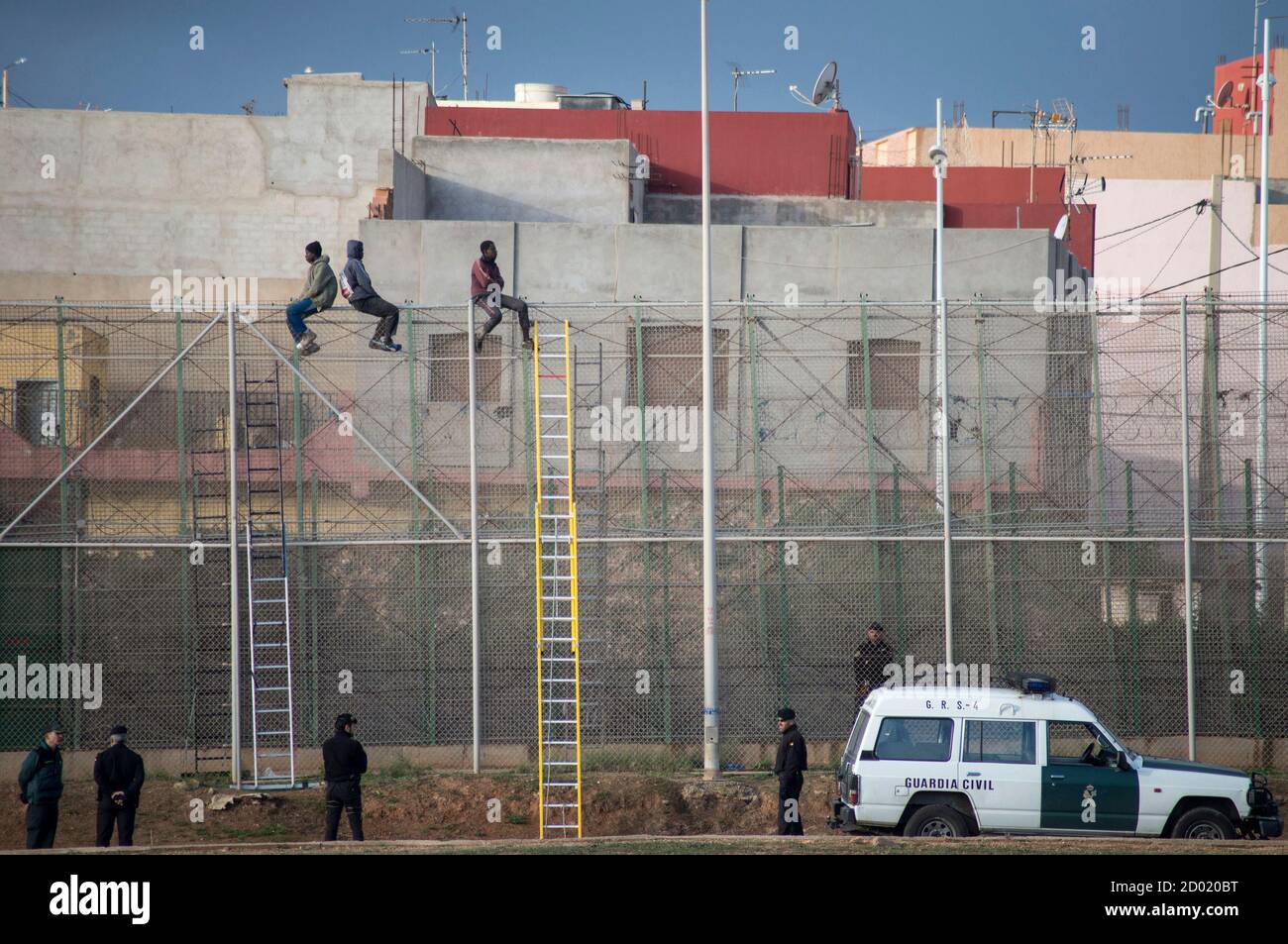 African Migrants Sit Atop A Border Fence As Spanish Civil Guard Officers Stand Under Them During An Attempt To Cross Into Spanish Territories Between Morocco And Spain S North African Enclave Of Melilla