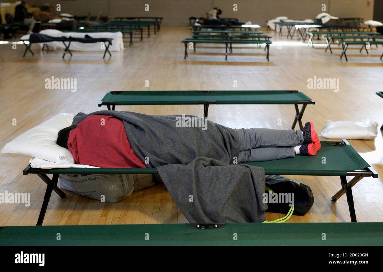 A man lies on a cot at a warming center as the temperature fell into the single digits in Atlanta, Georgia January 8, 2015.  Temperatures plummeted to an uncharacteristic 10 to 15 degrees overnight across the Gulf Coast, where a hard freeze warning was issued for east Texas across parts of Louisiana, Mississippi and southern Georgia, NWS said. REUTERS/Tami Chappell  (UNITED STATES - Tags: ENVIRONMENT SOCIETY) Stock Photo
