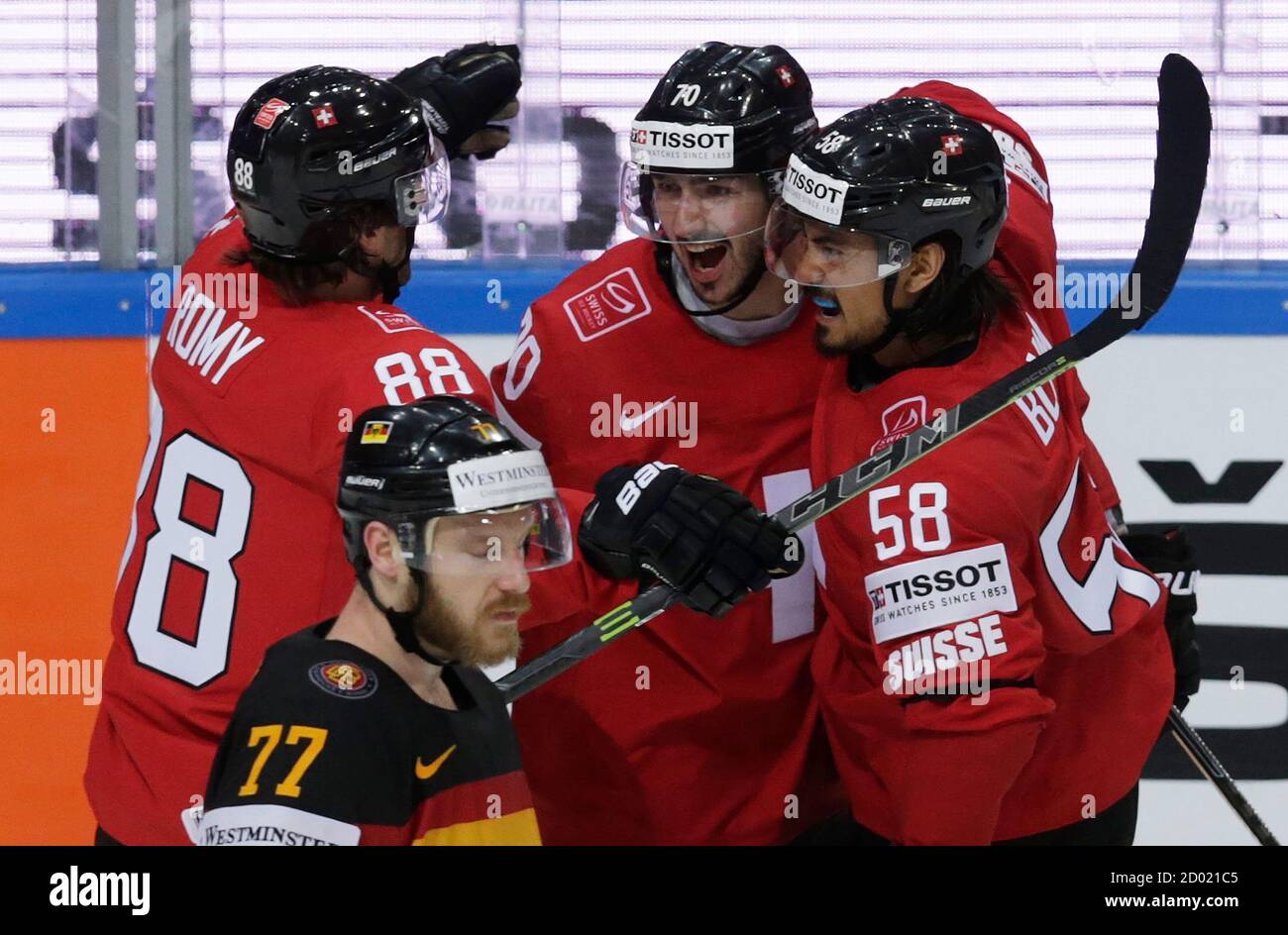 Switzerland's Denis Hollenstein (C) celebrates with teammates Kevin Romy  (L) and Eric Blum (R) after scoring against Germany during their Ice Hockey  World Championship game at the O2 arena in Prague, Czech