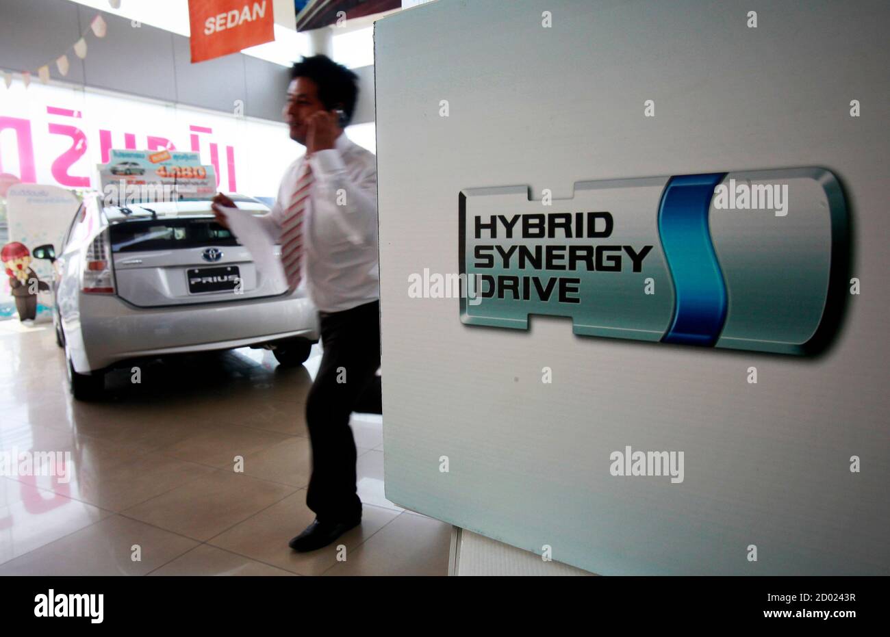 A car salesman talks on the phone behind a Toyota Prius in a showroom selling cars made in Thailand with parts imported from Japan, in downtown Bangkok May 12, 2011. The entire global auto industry has been hit by supply chain disruption since the March 11 earthquake and tsunami in Japan. But the domination of Japanese original equipment manufacturers in Southeast Asia makes the region particularly vulnerable, industry experts say. Analysts say the real impact on the sector is likely to be felt in the second half of 2011, affecting vehicle distributors and parts makers. To match Analysis AUTOS Stock Photo