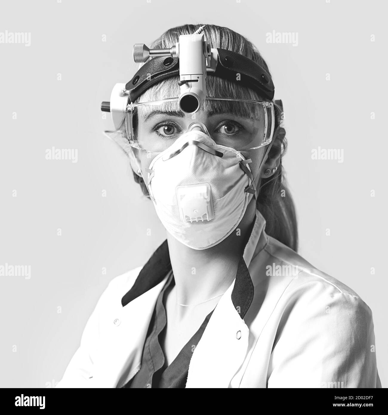 Confident ENT doctor wearing surgical headlight head light and protective glasses. Portrait of female otolaryngologist or head and neck surgeon on Stock Photo