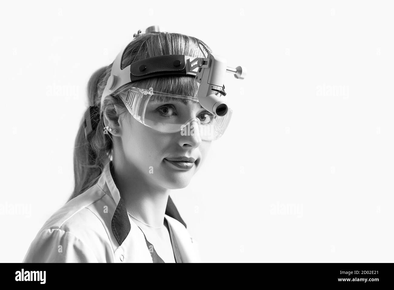Confident ENT doctor wearing surgical headlight head light and protective glasses. Closeup portrait of female otolaryngologist or head and neck Stock Photo