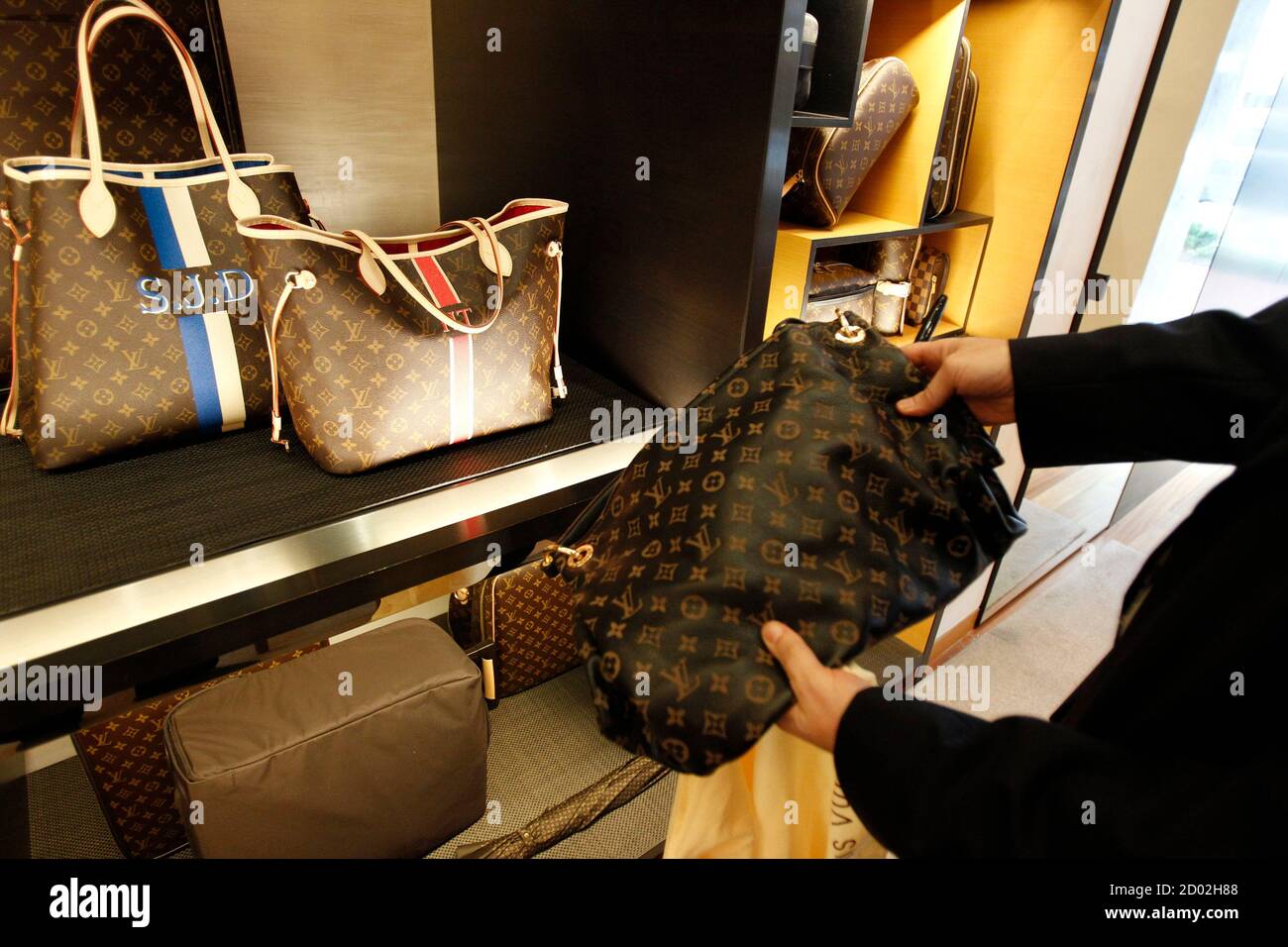 A fake LVMH handbag (R) purchased and shipped from a China -ased online  website is pictured next to products on display at a Louis Vuitton store in  Chevy Chase, Maryland, October 5,