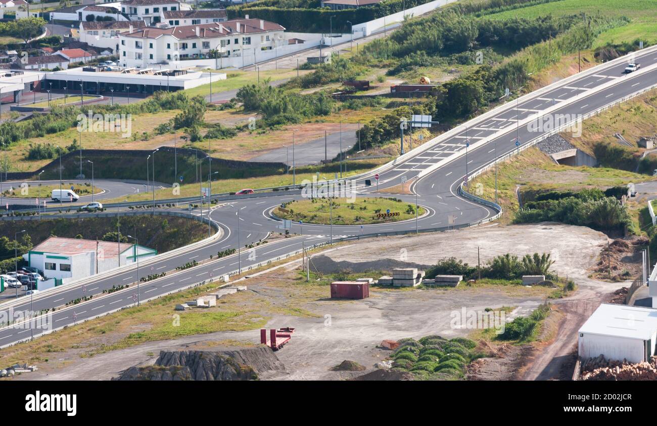 Transport intersection with a roundabout in the middle of the industrial zone and low-rise buildings. Stock Photo