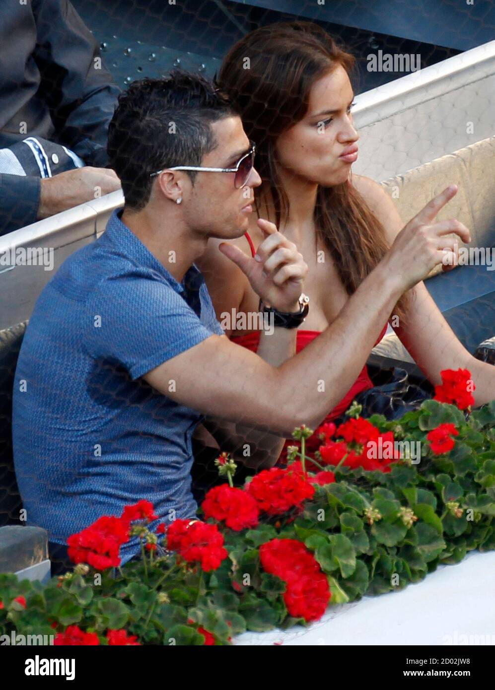 Real Madrid's Cristiano Ronaldo points as he speaks to his girlfriend Irina  Shayk (R) during the Madrid Open final tennis match between Novak Djokovic  of Serbia and Rafael Nadal of Spain in