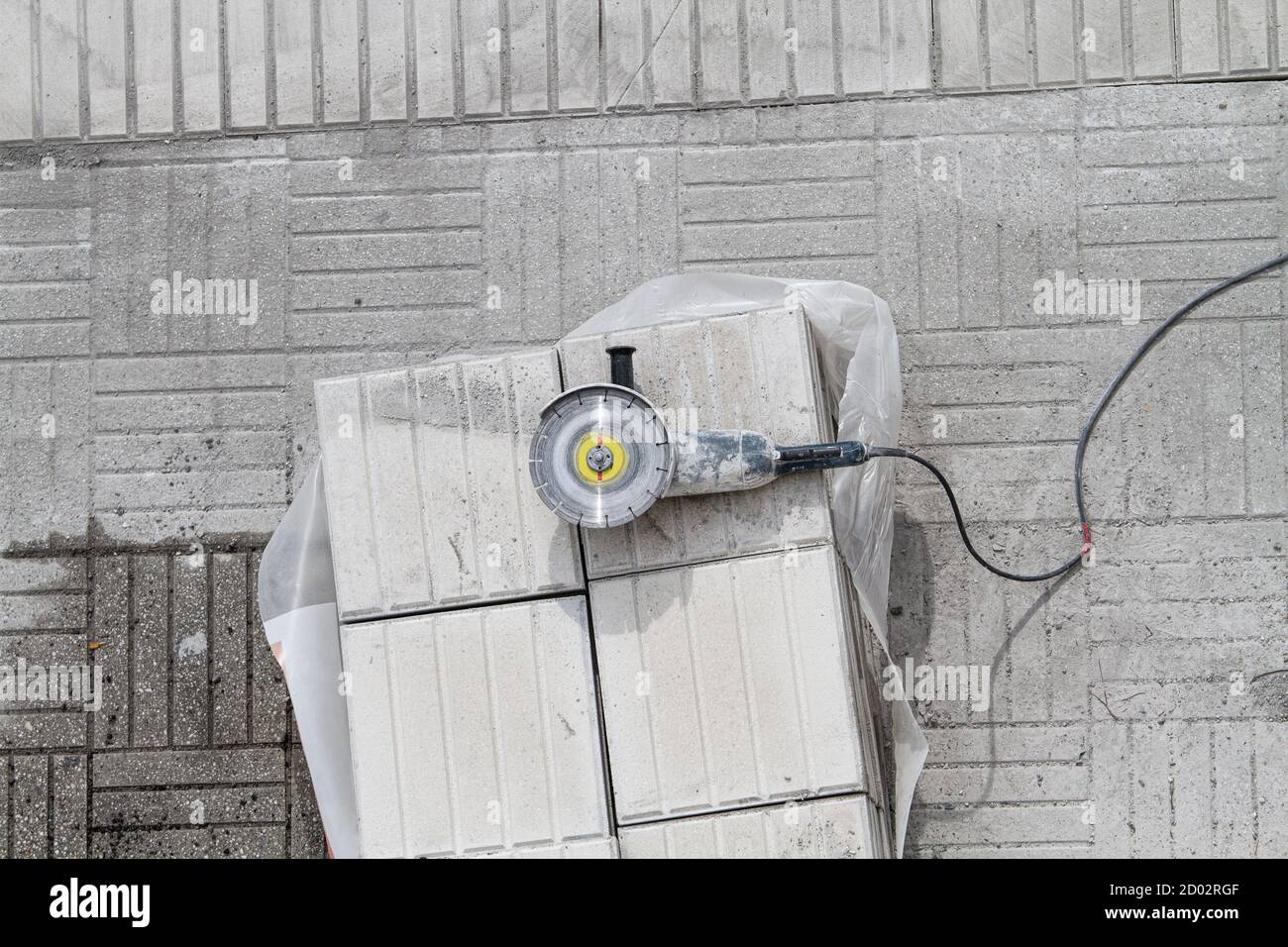 Angle grinder on a pile of paving tiles. Sidewalk under repair