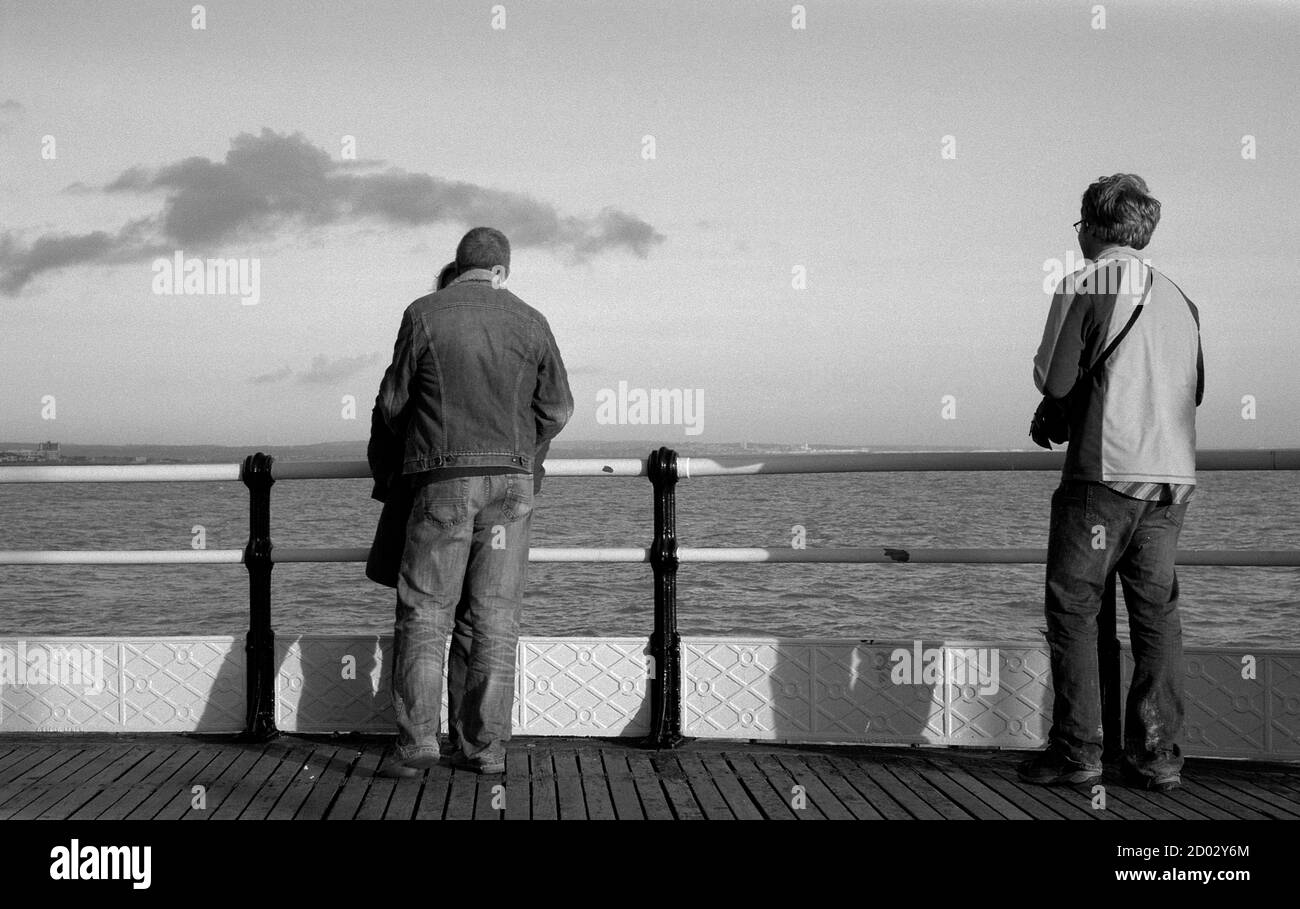 AJAXNETPHOTO. WORTHING, ENGLAND. - TO THE EAST - A COUPLE ON THE EAST SIDE OF THE PIER HEAD WITH A PERSON LOOKING ON. PHOTO:JONATHAN EASTLAND/AJAX REF:81201_5_2 Stock Photo