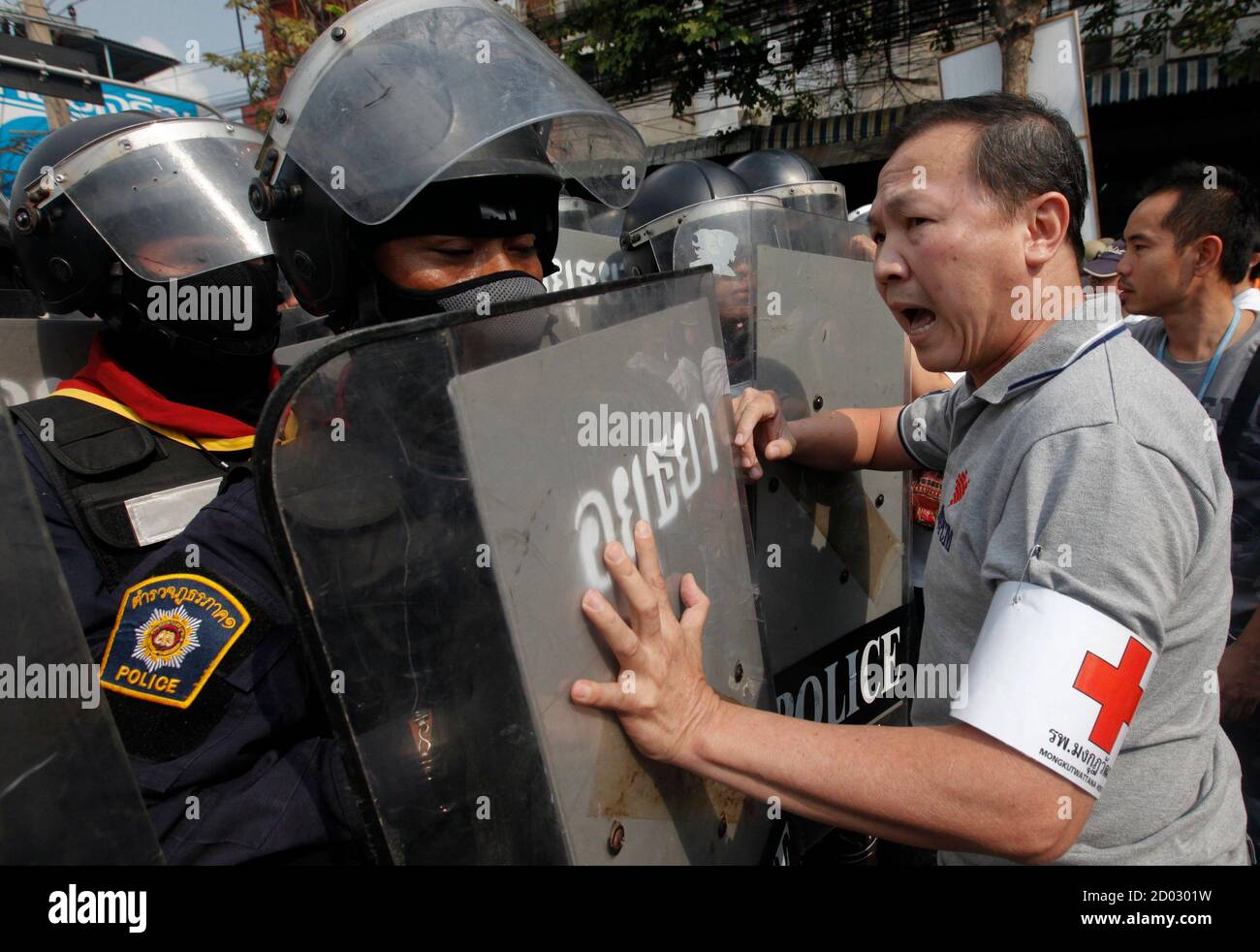 An anti-government protester pushes the shields held by riot police at a barricade near the Government Complex in Bangkok February 14, 2014. Thousands of Thai riot police were deployed on Friday to seize back protest sites around government buildings in Bangkok that have been occupied for months by demonstrators seeking to topple Prime Minister Yingluck Shinawatra. REUTERS/Kerek Wongsa (THAILAND - Tags: POLITICS CIVIL UNREST) Stock Photo