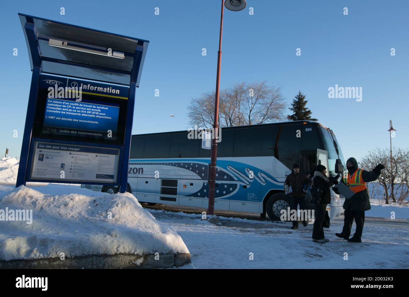 An AMT (Agence metropolitaine de transport) worker directs commuters as  they arrive from the Vaudreuil-Dorion train station by special bus in  Dorval, Quebec, February 16, 2015. Canadian Pacific Railway Ltd began  operating