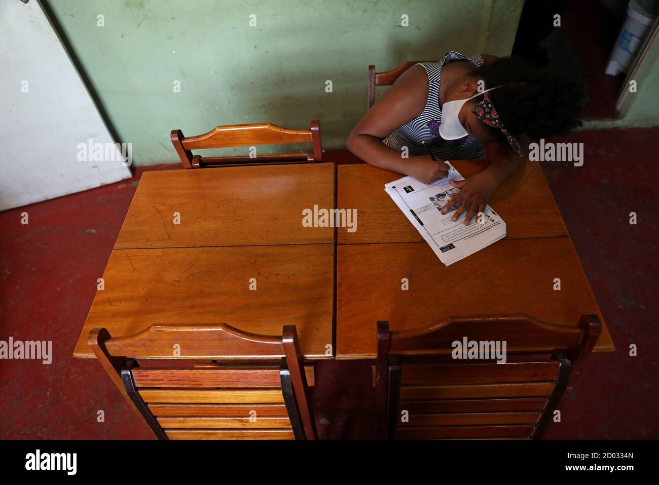 Rebecca Sabino, 8, does her homework as part of the Educacao na Quarentena project (Quarantine Education), as public schools are still closed, at her family's snack bar at Prazeres slum in Rio de Janeiro, Brazil October 1, 2020. Picture taken October 1, 2020. REUTERS/Pilar Olivares Stock Photo