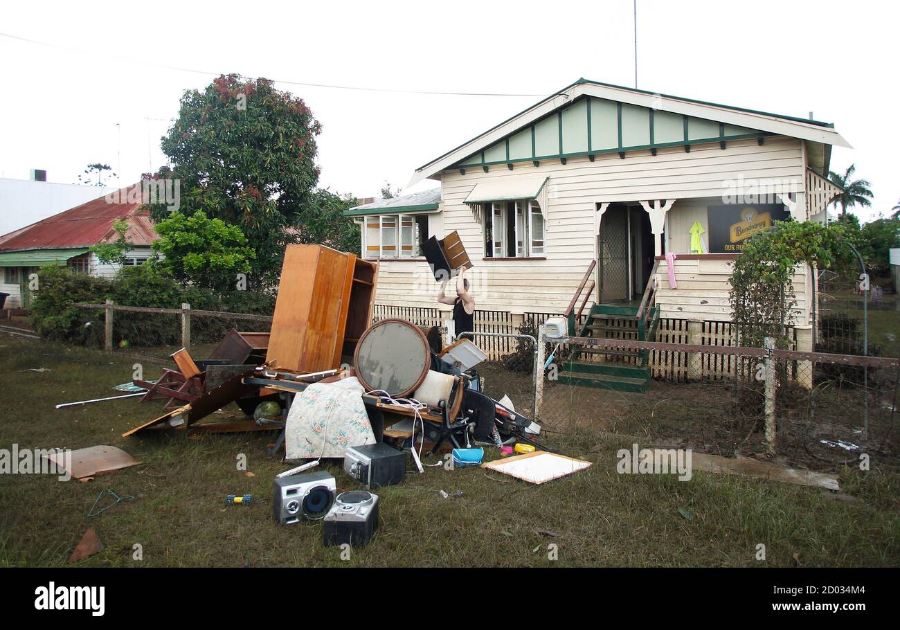 A Man Discards Furniture Affected By Flood Waters In Bundaberg Queensland Australia January 1 2011 Flood Waters Rose Across Australia S Northeast On Friday Covering An Area Bigger Than France And Germany Combined