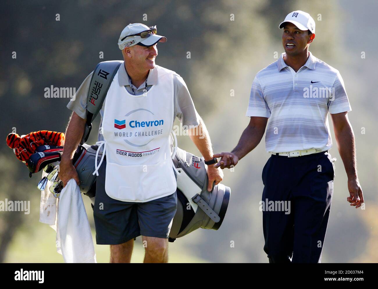 Tiger Woods talks with his caddie Joe LaCava (L) as he carries Tiger's new  golf bag on the 18th fairway during a pro-am round at the Chevron World  Challenge golf tournament in