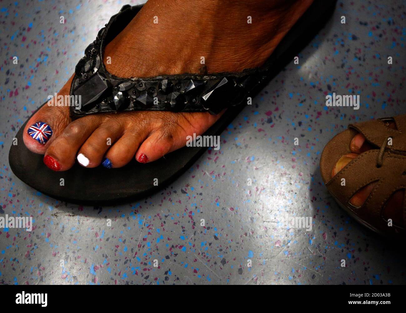 A woman riding the subway has her toe nail painted with the Union Jack ahead of the 2012 London Olympic Games in London July 26, 2012.  REUTERS/Brian Snyder  (BRITAIN - Tags: SPORT OLYMPICS SOCIETY) Stock Photo