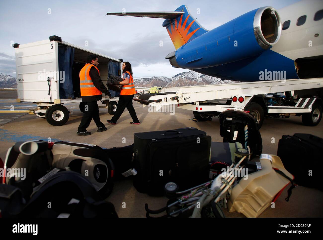 Baggage handlers unload a McDonnell Douglas MD-80 series passenger jet belonging to Allegiant Air at the Ogden-Hinckley Airport in Ogden, Utah, March 11, 2013. Picture taken March 11, 2013. REUTERS/Jim Urquhart (UNITED STATES - Tags: TRANSPORT BUSINESS) Stock Photo