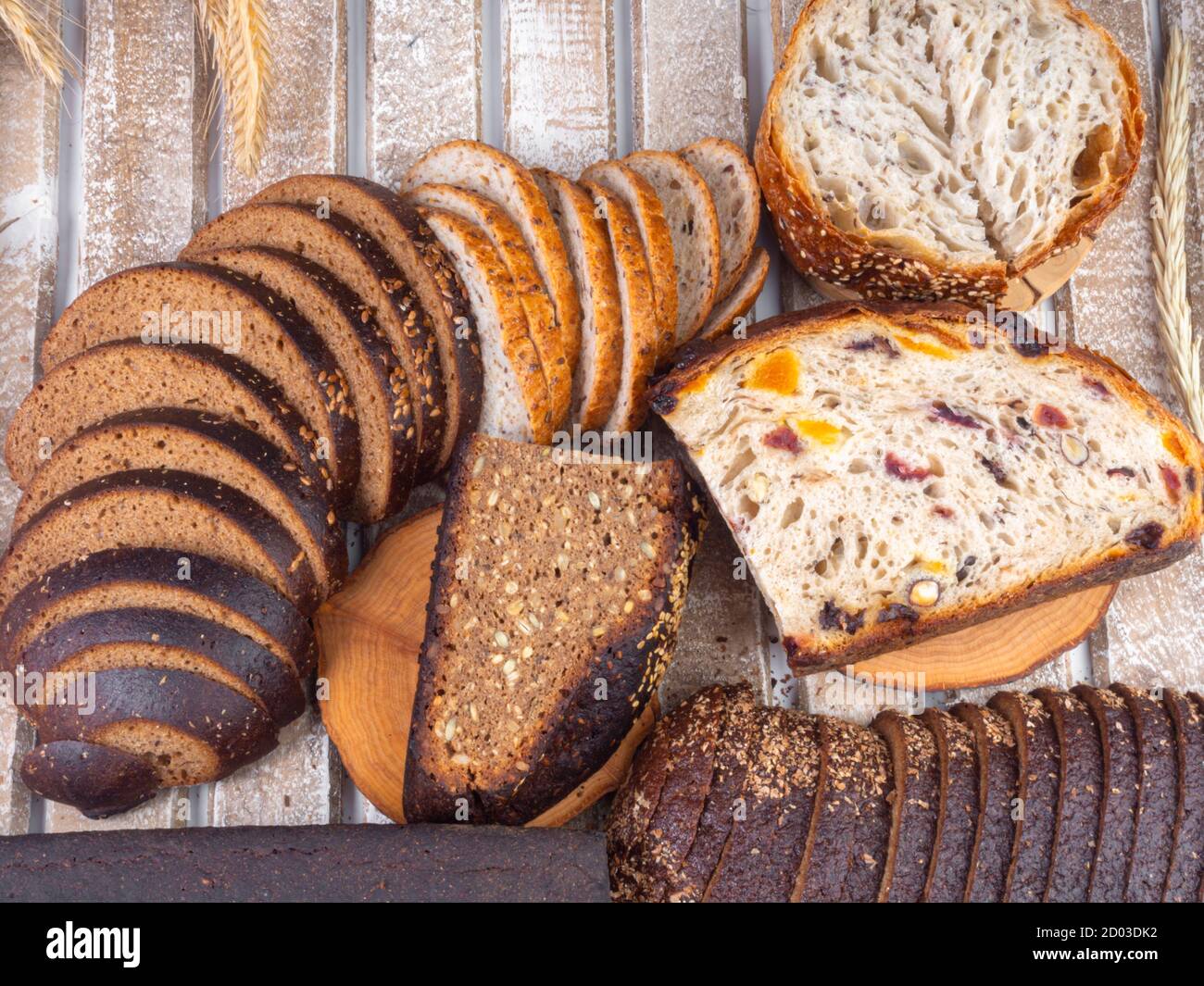 assortment of different freshly baked breads on wooden table Stock Photo