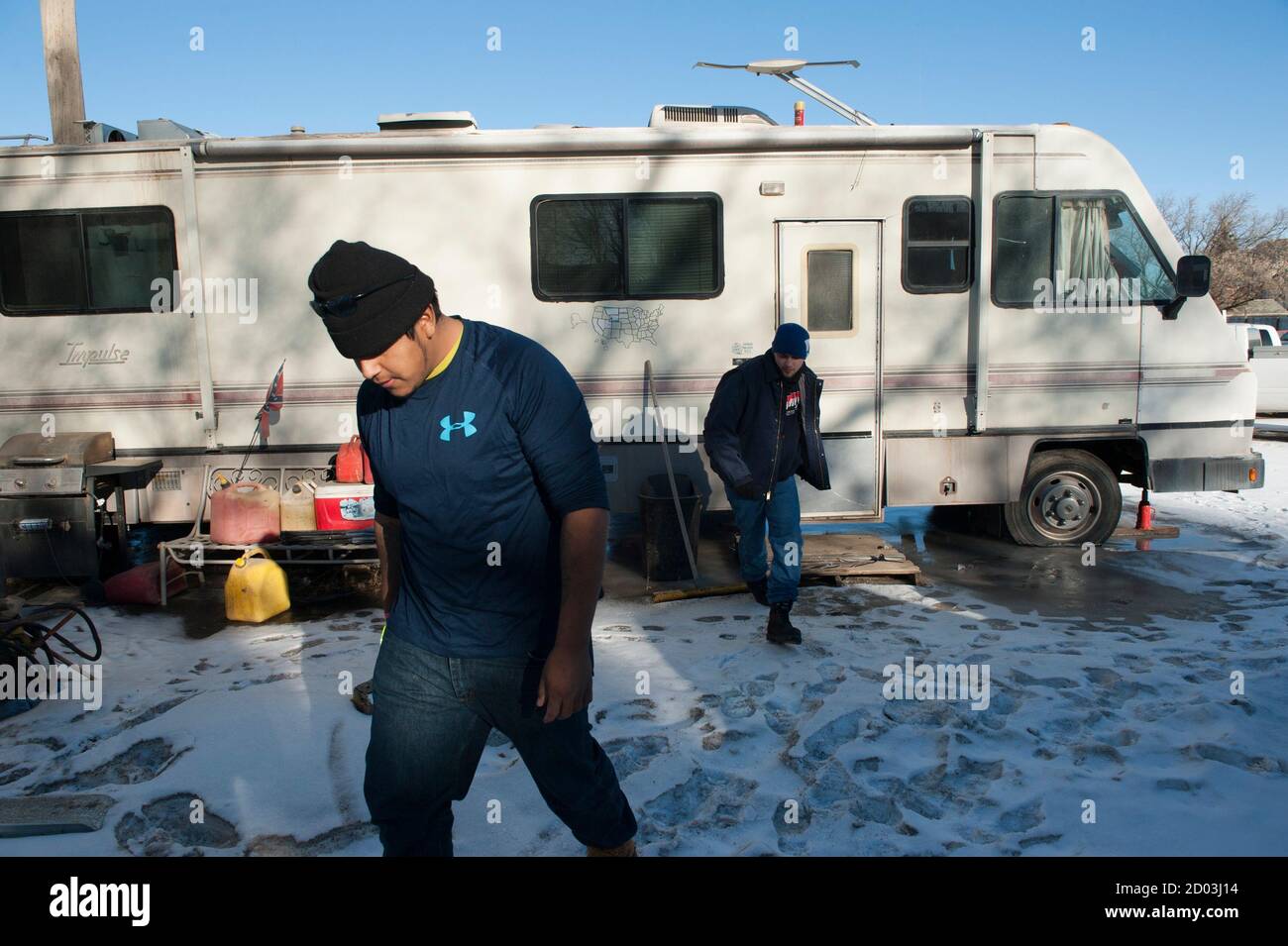 Bazileo Hernandez (L) and his friend Jeff Williamson leave an RV they are staying in, in Williston, North Dakota January 23, 2015. Like so many before them, Terra Green, Jeff Williamson and Bazileo Hernandez came to North Dakota's oil country seeking a better life. They just came too late. Itinerant, unskilled workers could as recently as last spring show up in the No. 2 U.S. oil producing state and vie for salaries north of $100,000 per year with guaranteed housing. The steep drop in oil prices has changed that. After trying unsuccessfully for over a month to find work, the friends decided to Stock Photo