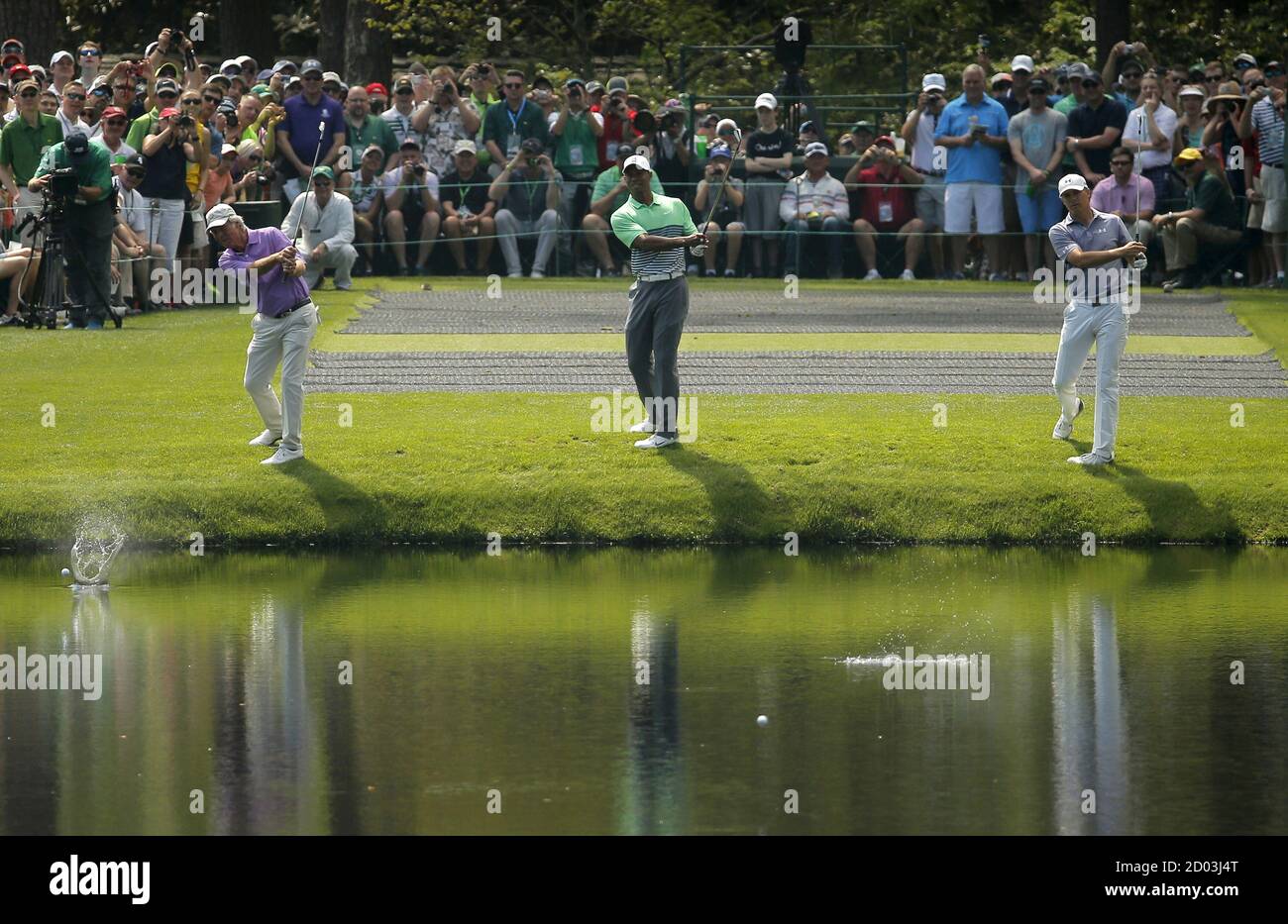 Jordan Spieth (R) skips a ball aross water to the 16th green with Tiger Woods (C) and Ben Crenshaw during their practice round ahead of the 2015 Masters at Augusta National Golf Course in Augusta, Georgia April 8, 2015. Spieth's sublime putting on some of the most treacherous greens in golf, which set up his Masters victory on Sunday, was underpinned by his imaginative touch, says putting maestro Crenshaw. Picture taken April 8, 2015.  REUTERS/Brian Snyder Stock Photo