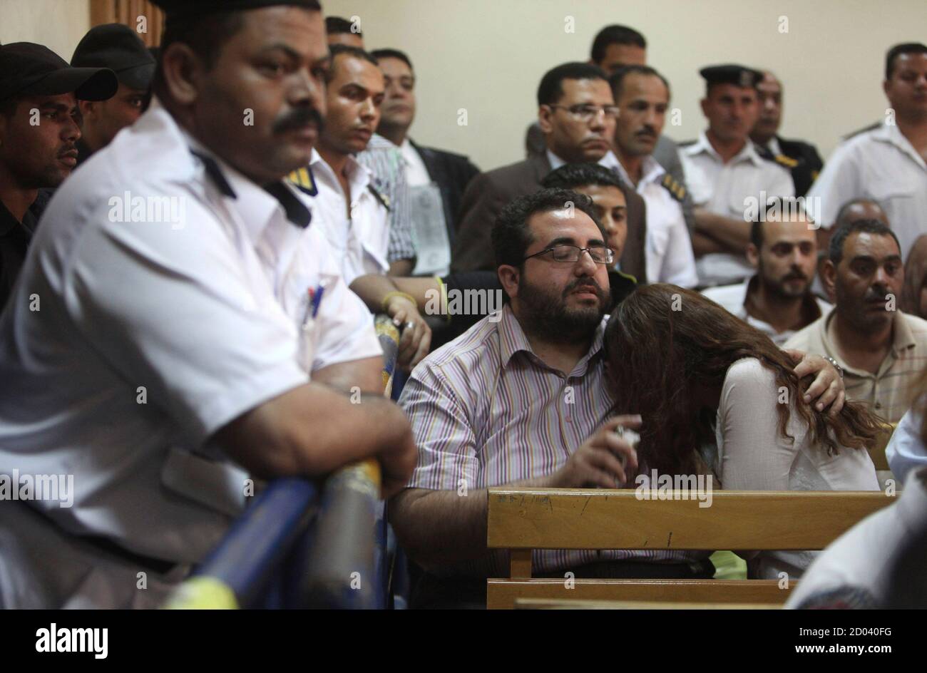Friends of Egyptian suspects react as they listen to the judge's verdict at a court room during a case against foreign non-governmental organisations (NGOs) in Cairo June 4, 2013. An Egyptian court sentenced at least 15 U.S. citizens in absentia to five years in jail on Tuesday and one American who stood trial was jailed for two years in a case against private foreign groups seeking to promote democracy. Judge Makram Awad also ordered the closure of the NGOs, including the U.S.-based International Republican Institute and the National Democratic Institute. He gave five-year sentences in absent Stock Photo