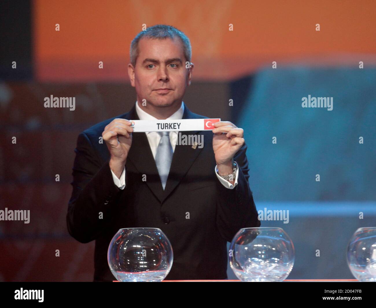 FIBA Europe competition coordinator Richard Stokes holds up a slip of paper  with the name "Turkey" during the 2011 FIBA European Championship draw in  Vilnius January 30, 2011. REUTERS/Ints Kalnins (LITHUANIA -